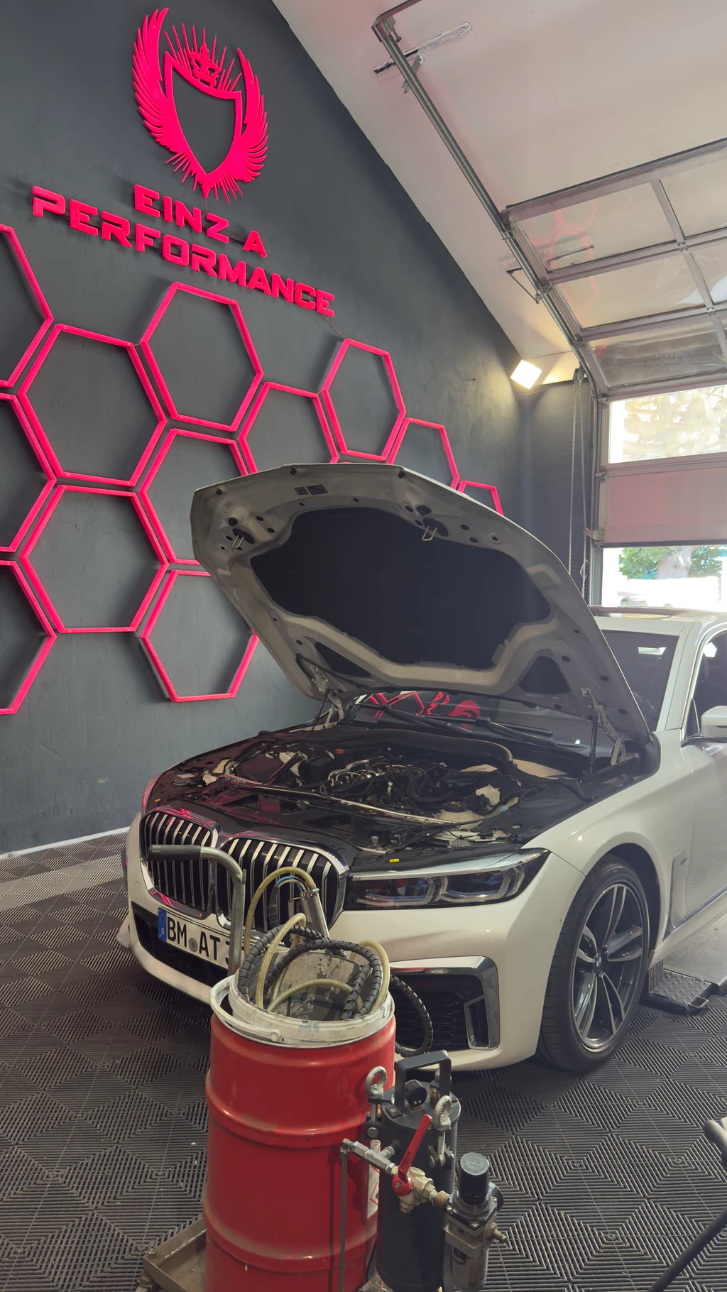 BMW mit offener Motorhaube und Walnussgranulat-Reinigungsgerät in der Werkstatt von Einz A Performance