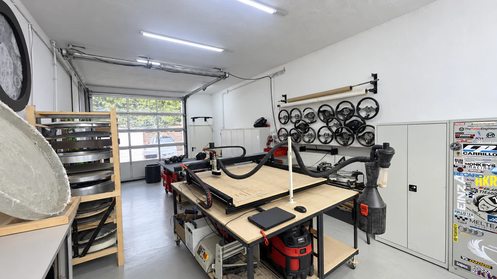 Werkstattbereich von Einz A Performance mit CNC-Arbeitstisch und Lenkrädern